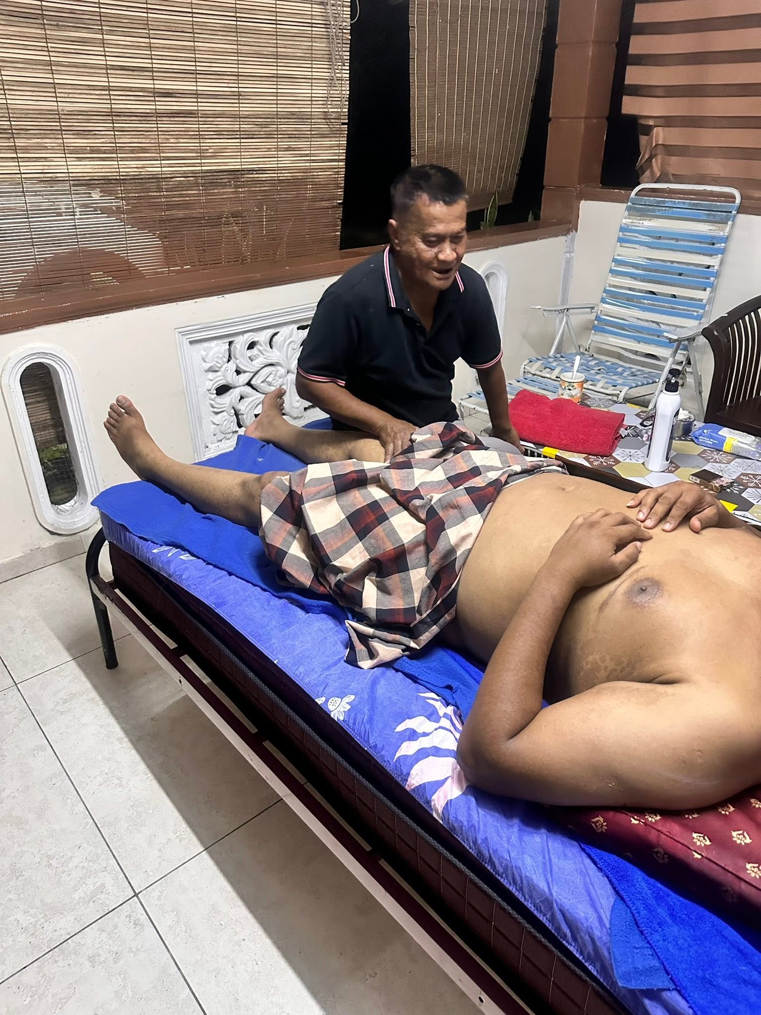 Pak Ali menjalankan sesi urutan kaki untuk pelanggan lelaki